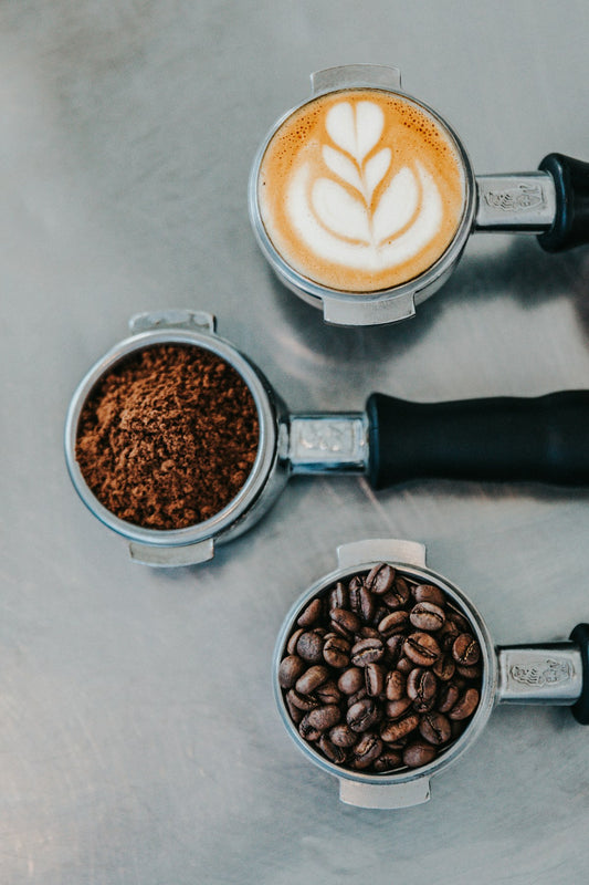 Coffee beans, grounds, and espresso in portafilters showing the journey from bean to cup