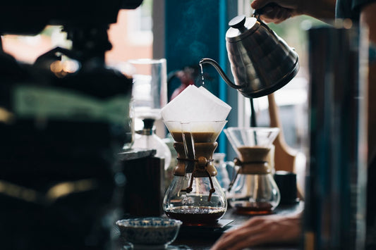 A warm cup of coffee held in hand, highlighting the rich colour and inviting aroma of freshly brewed specialty coffee