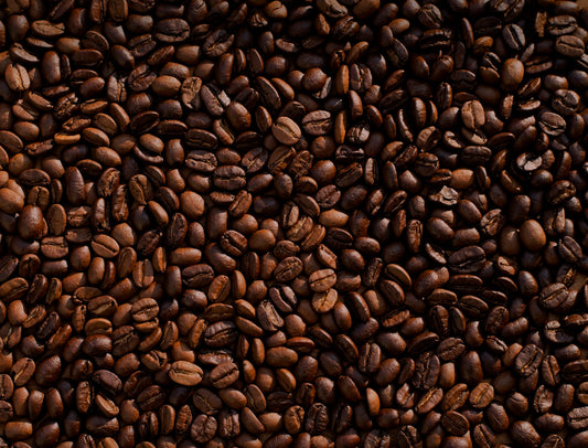 Freshly roasted coffee beans scattered on a surface showing variety and quality