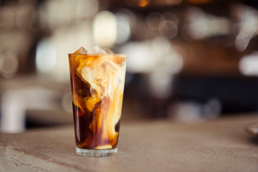 Glass of cold brew coffee with ice on a wooden surface