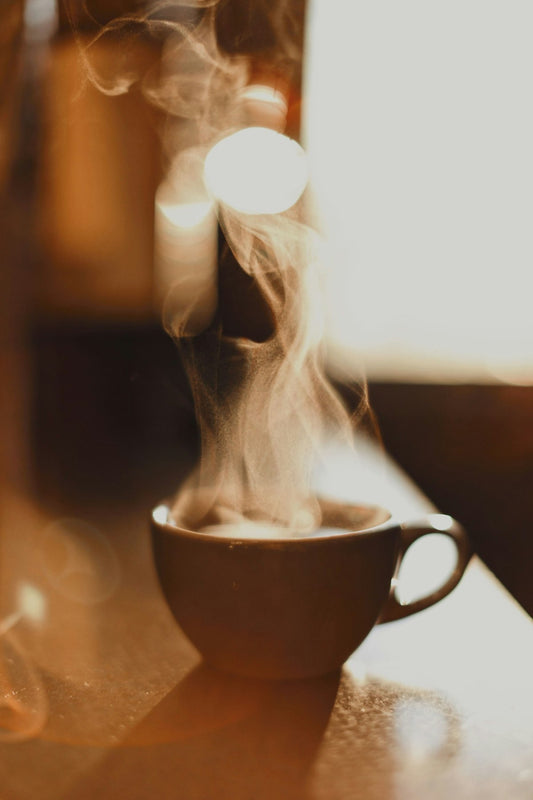 A steaming cup of coffee in a brown ceramic mug representing a healthy daily coffee habit