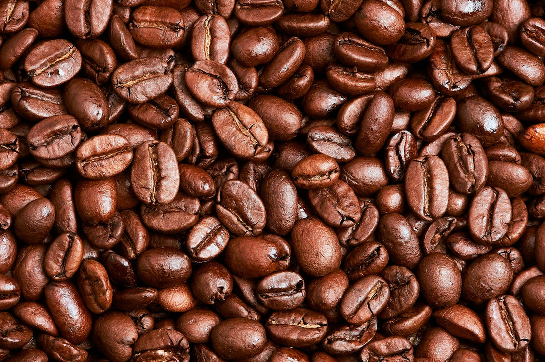 Close-up of whole roasted coffee beans on a wooden surface