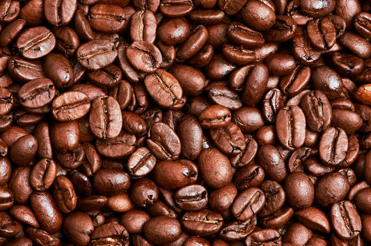 Close-up of whole roasted coffee beans on a wooden surface