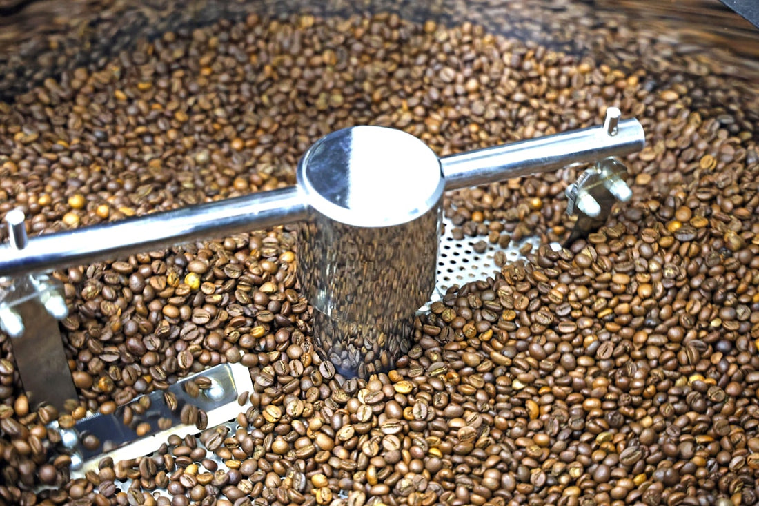 Coffee beans being roasted and stirred inside a coffee roasting machine